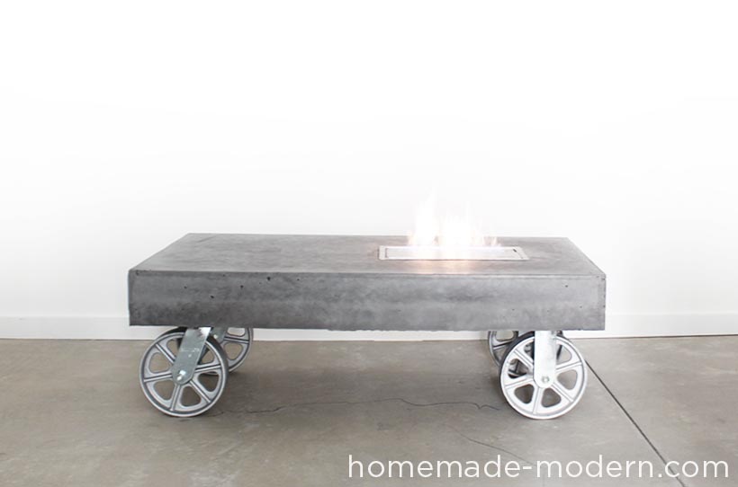 This modern concrete fireplace doubles as a coffee table on wheels. I used Quikrete 5000 cement mix poured into a melamine mold to make the table and added charcoal pigment from Quikrete to give the concrete a dark grey color. The manufacturer of the fireplace insert claims that bio-ethanol fuel is safe indoors and out, but I would only use the table outdoors. I was curious about ethanol fireplaces so I bought one from Moda Flame (not a sponsor) and made a simple, concrete table on wheels out of Quikrete 5000 that has an opening to accommodate an ethanol fireplace burner. For more information go to HomeMade-Modern.com.